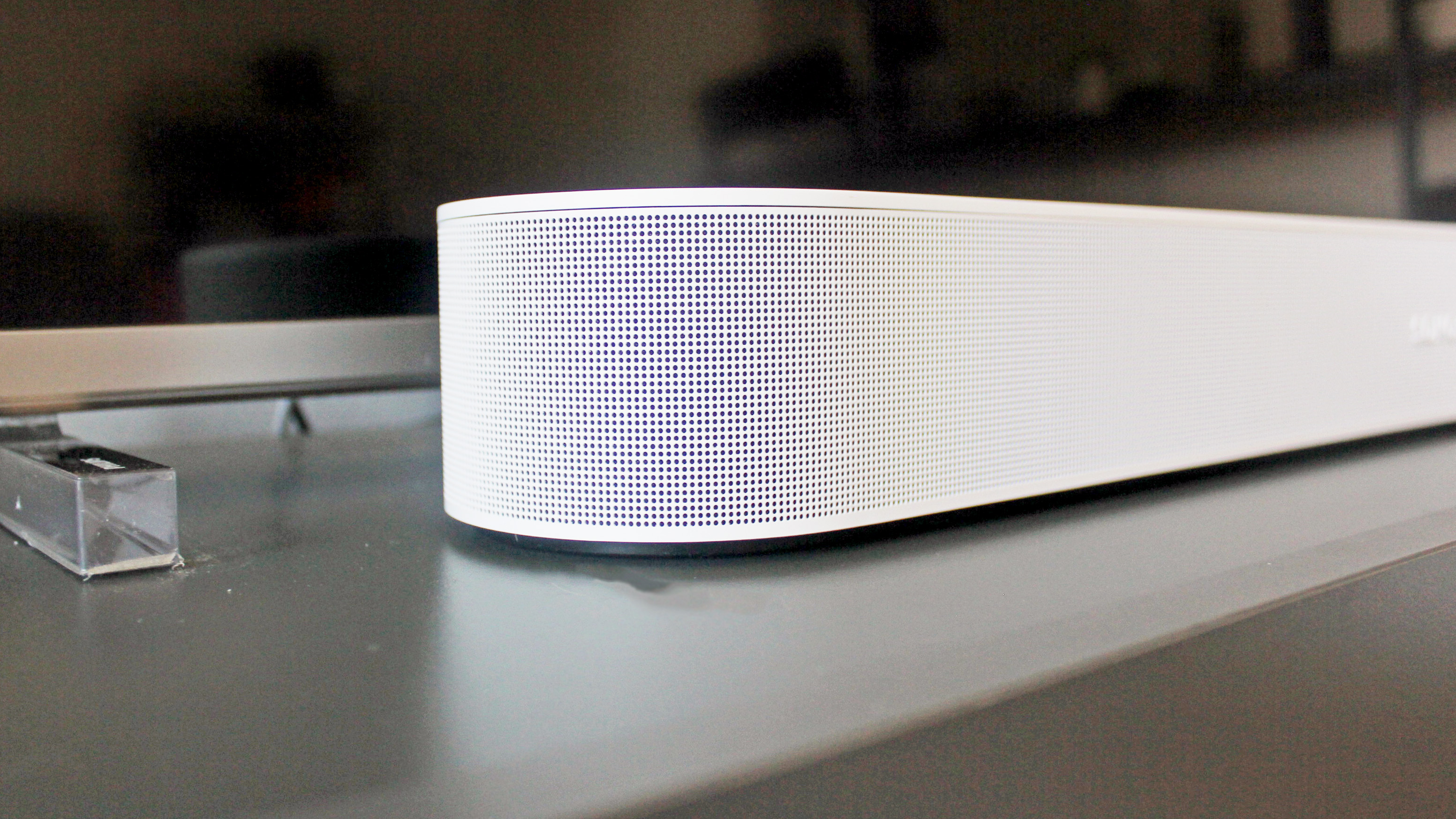 A close up of the side of the sonos beam gen 2 soundbar in white under a TV screen